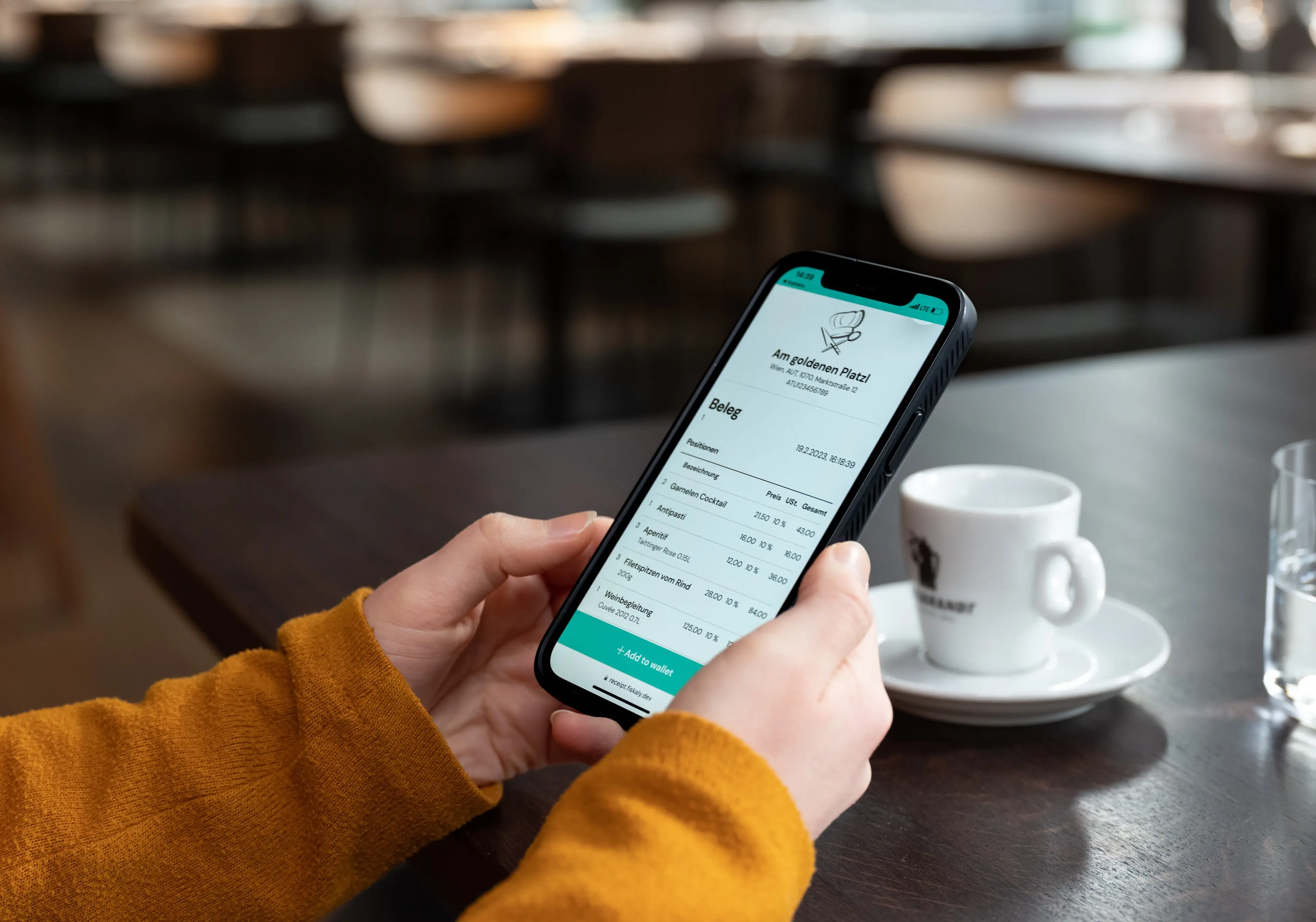 Frauenhände in einem orangefarbenen Pullover, die ein Mobiltelefon mit einer elektronischen Quittung in der Hand halten