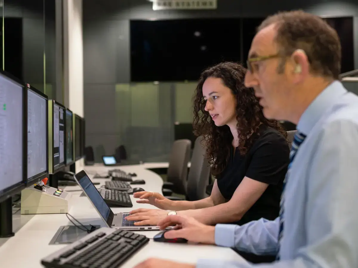 Two people, possibly software vendors, sit in front of computer screen and see how easily TBAI API by fiskaly adapts to ERP, POS, PMS