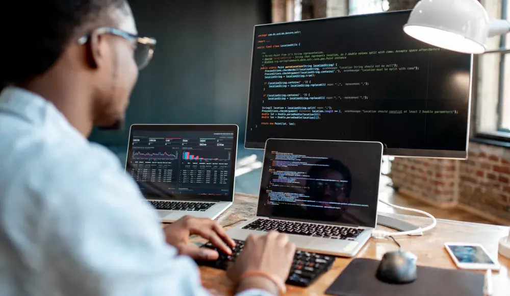 Man in from of laptops and a screen with VeriFactu API software, compliant with anti-fraud law in Spain via SIGN ES by fiskaly 