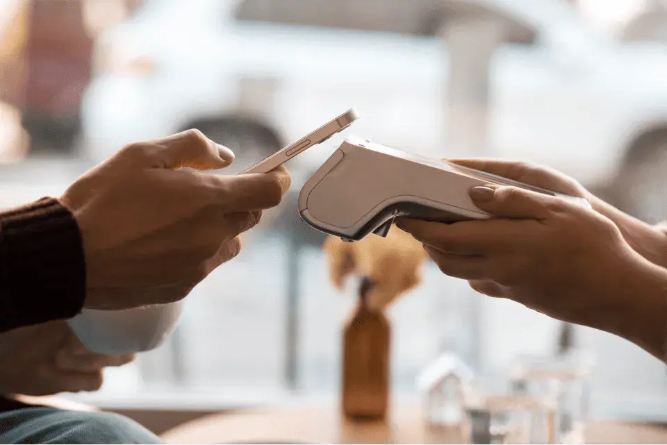 Person pays by phone on POS and VeriFactu API by fiskaly ensures seamless integration among business software & Anti-fraud law and VeriFactu