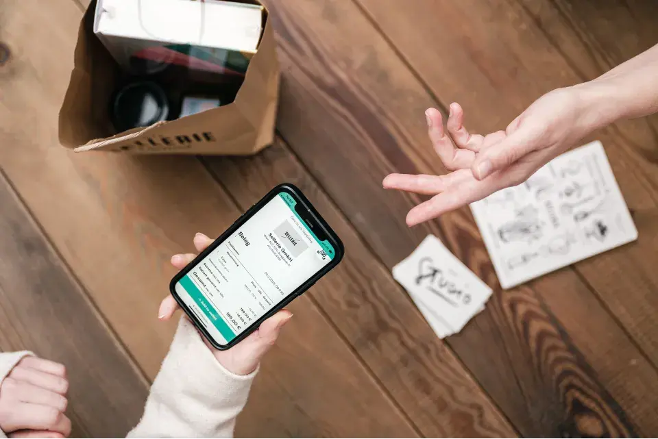 Hand with a mobile phone, wanting to pay with QR code for the purchase in a shop
