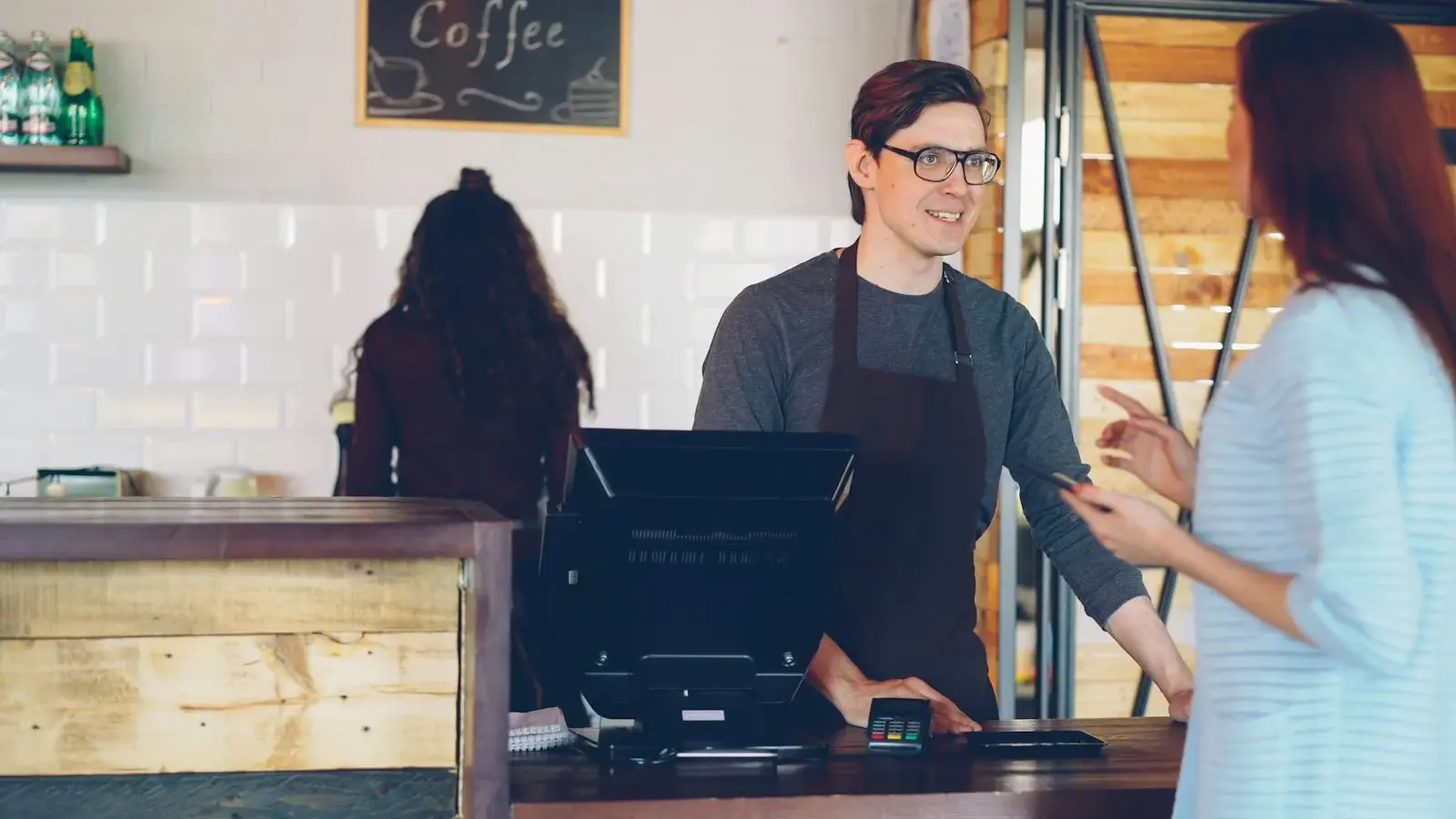 A customer paying at a café counter — fiscalization for Swedish retail and hospitality POS providers