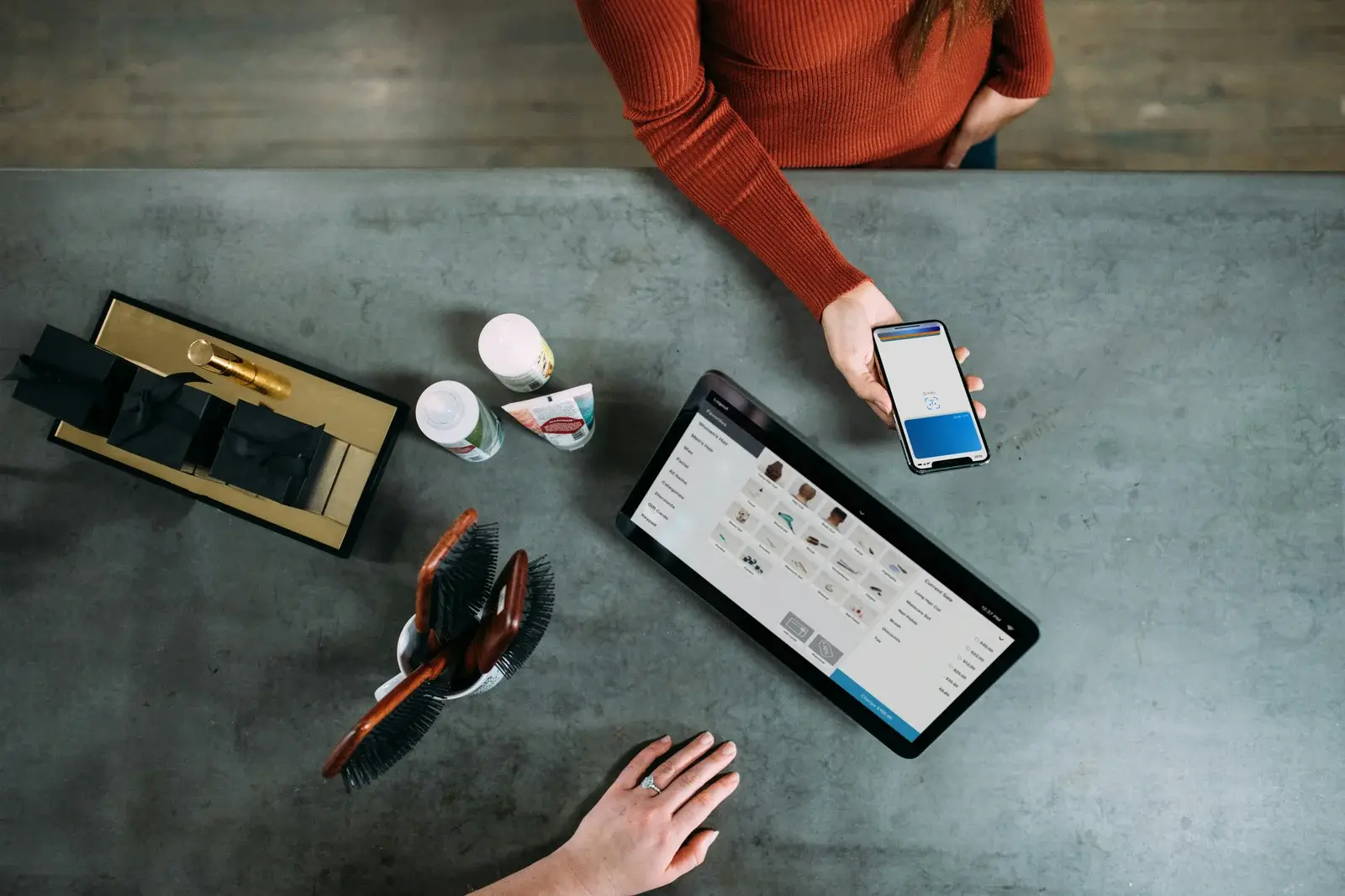 Customer paying at the checkout counter of a small shop with a POS terminal