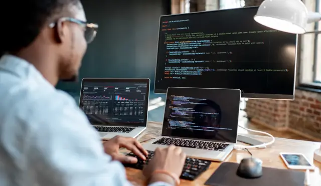 Man in front of laptops and a screen with VeriFactu API software