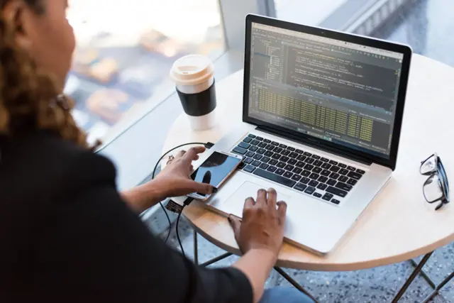 Woman in front of the laptop with software