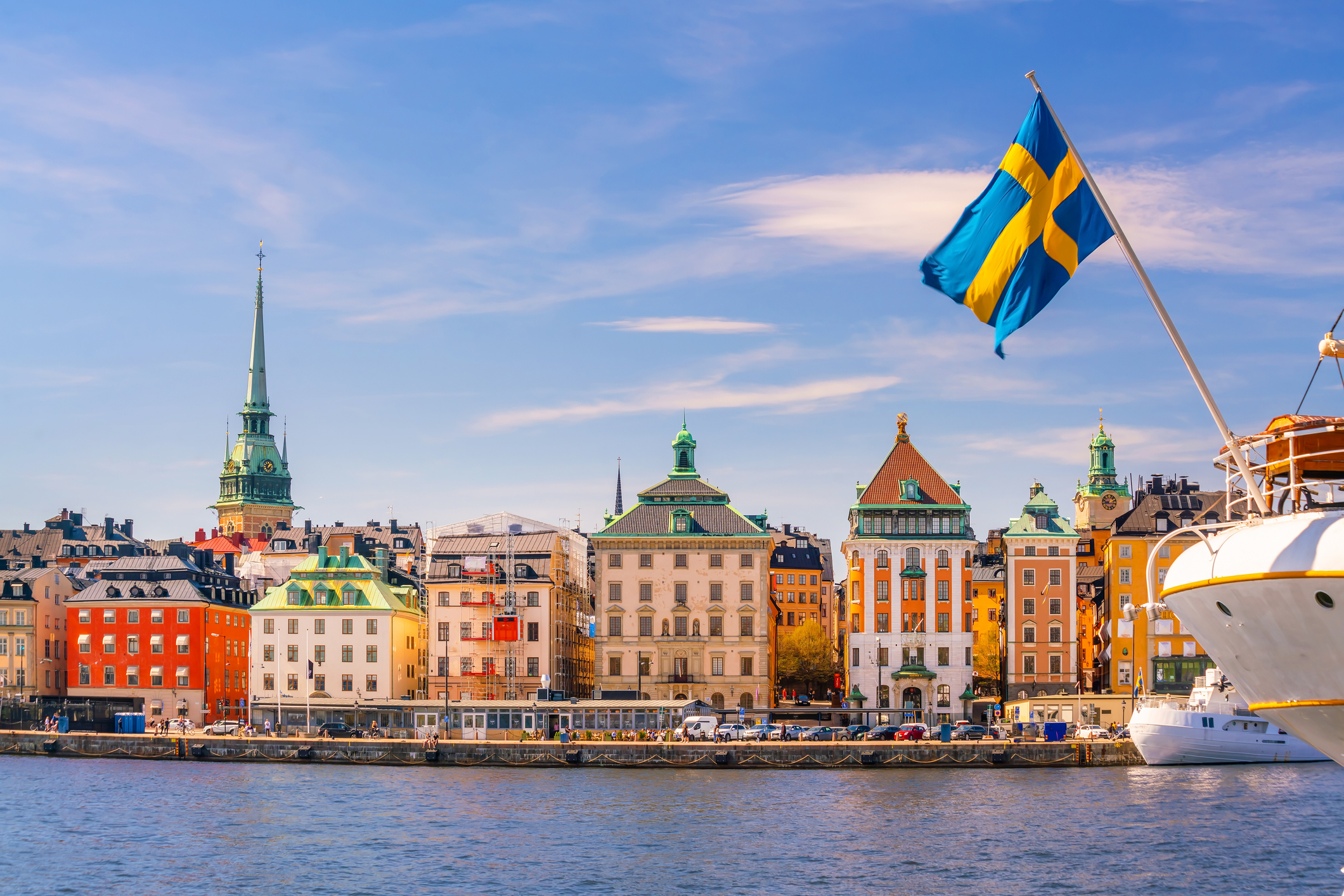 Schiff mit schwedischer Flagge vor bunten Häusern in Stockholm