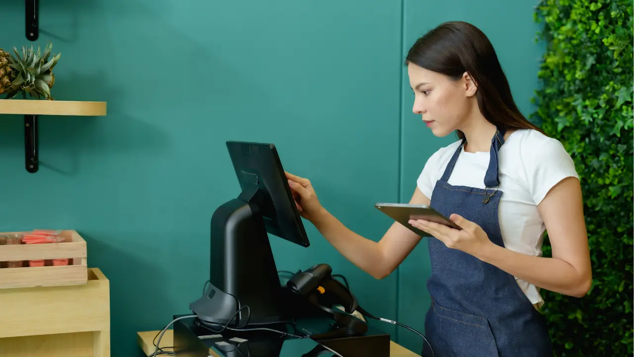 Cashier using a certified POS system in France, operating an NF525-compliant cash register that ensures data security and integrity.
